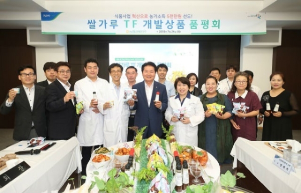 김병원 농협중앙회장(가운데)과 참석자들이 각자 이날 선보인 쌀가루 신상품을 손에 들고 기념촬영을 하고 있다.(사진=농협)