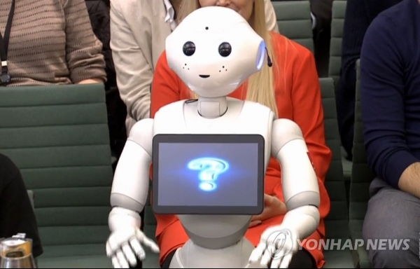 사진= 2018년 세계 최초 감정인식 로봇 '페퍼'가  영국 런던에서 열린 하원 교육특별위원회 청문회에 참석하고 있다. 국제연구프로젝트 '케어스'(Caress)의 일환으로 제작된 '페퍼'는 이날 청문회에서 "좋은 아침입니다"라고 인사한 뒤 4차 산업혁명과 관련해 인간의 역할이 무엇인지를 묻는 한 의원의 질문에 "로봇은 앞으로 중요할 역할을 할 것입니다. 그러나 우리는 소프트 기술이 필요한데, 이는 인간을 대신할 수가 없습니다"라고 답해 박수갈채를 받았다.