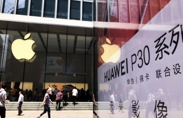 중국 상하이 난징둥루에 있는 애플 스토어 앞에 화웨이의 전략 스마트폰 P30 시리즈 광고물이 서 있다.