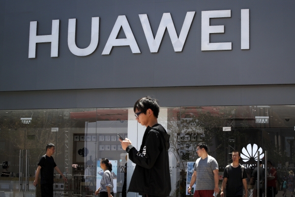 중국 베이징의 화웨이 매장 밖에서 한 남성이 스마트폰을 사용하고 있다. (베이징=AP 연합뉴스)