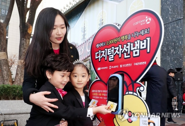 지난 2일 부산 부산진구 롯데백화점 앞 광장에서 어린이들이 교통카드를 이용해 디지털 자선냄비에 기부하는 모습