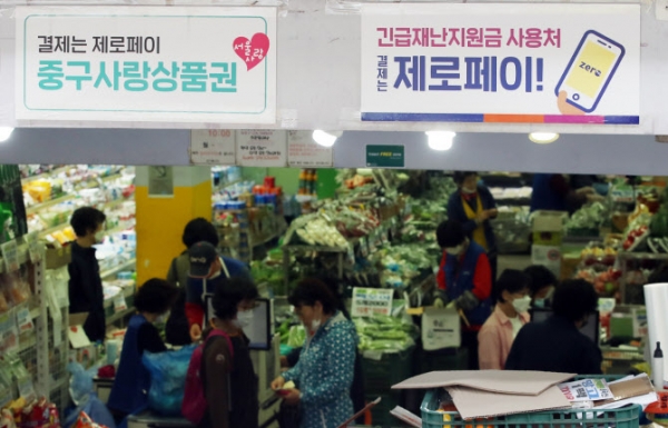 지난 19일 서울 중구 약수시장의 한 소규모 마트에 긴급재난지원금 사용 가능 안내문이 붙어 있다. (사진=연합뉴스)