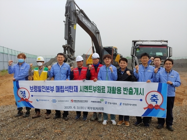 한국중부발전 보령발전본부 매립석탄재 시멘트원료 재활용 반출을 개시하며 관계자들이 기념촬영을 하고 있다